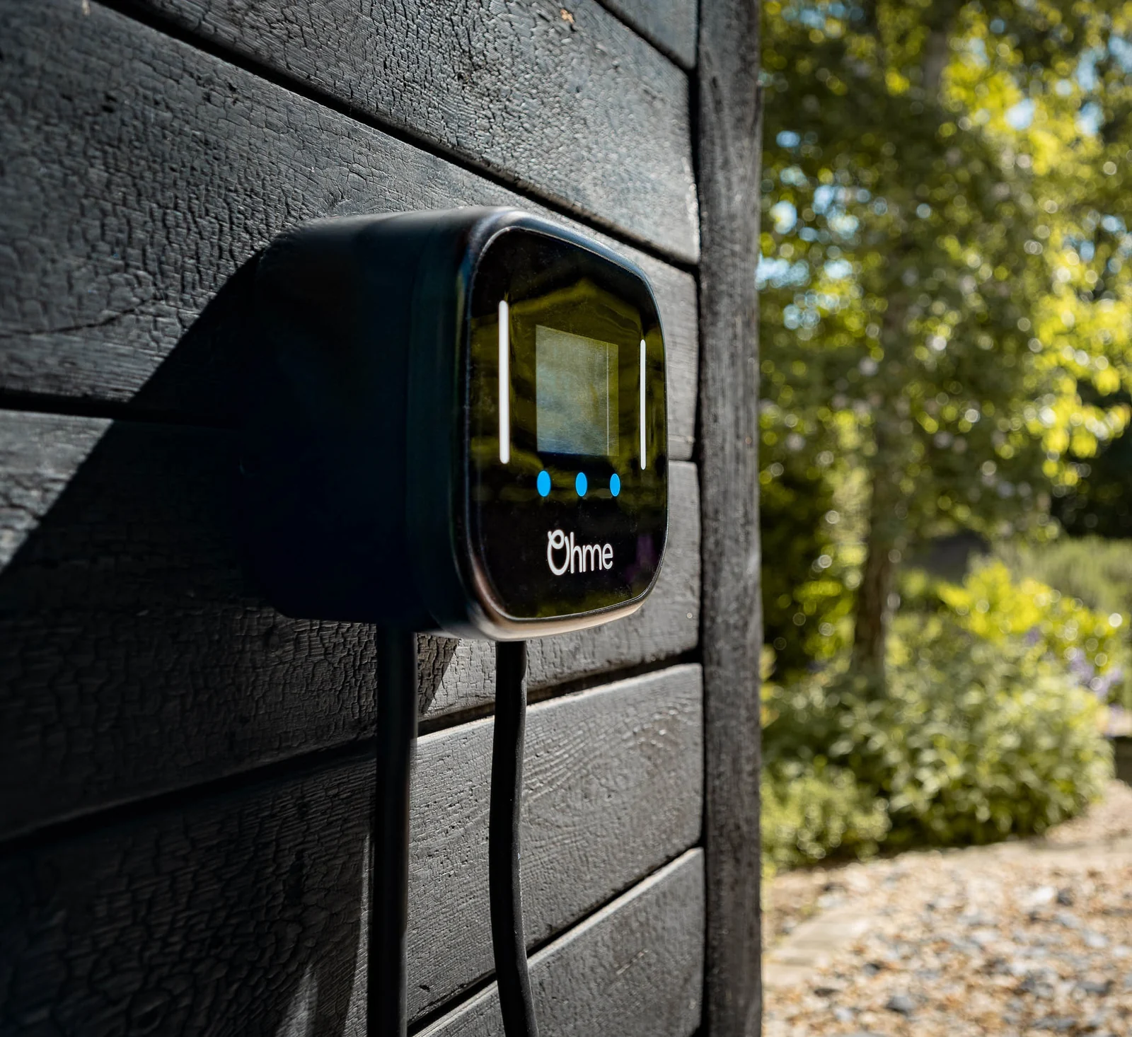Ohme Home Pro EV charger mounted on dark timber cladding