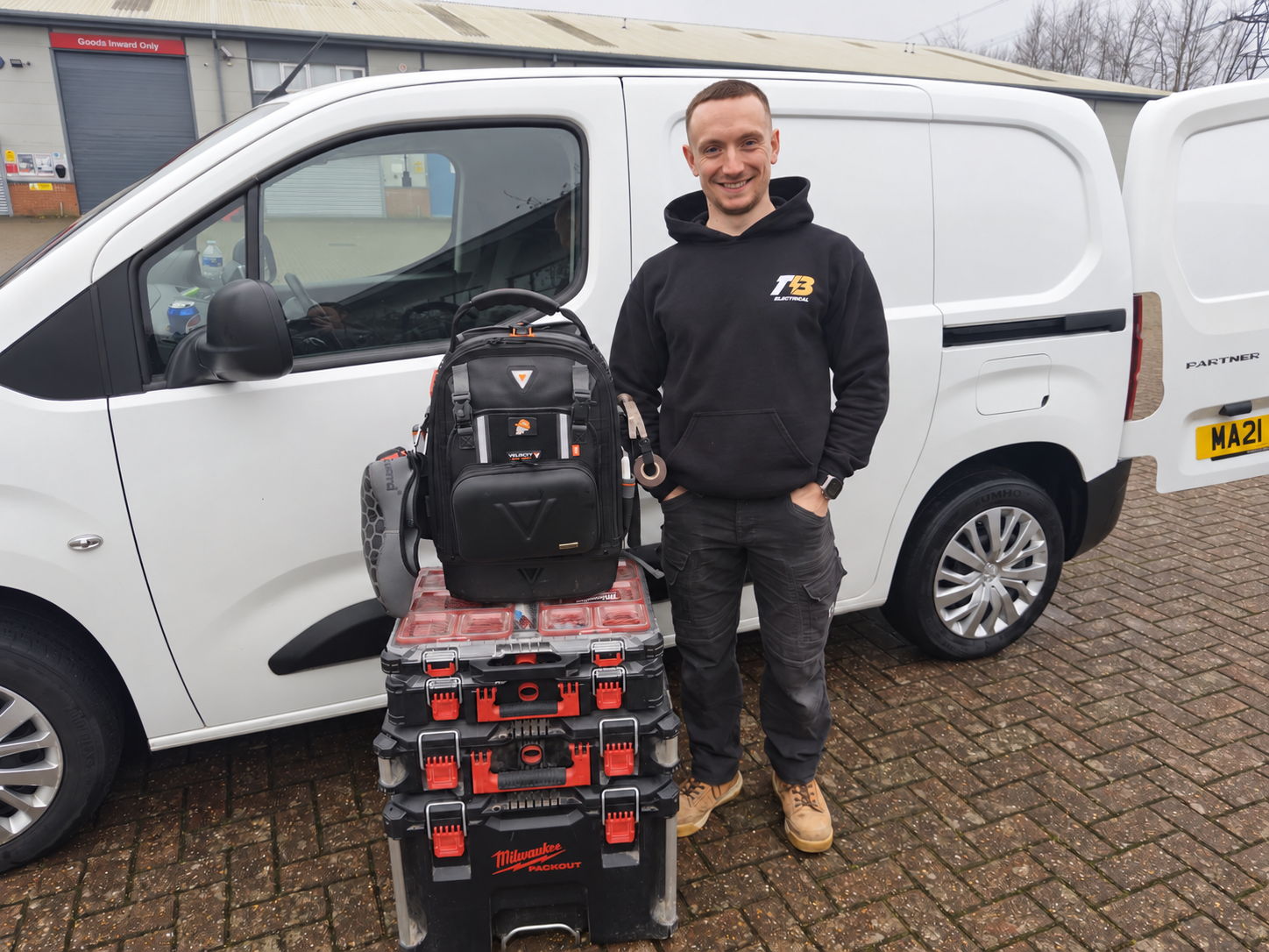 Tyler Baker in his TB Electrical uniform beside his van and toolboxes